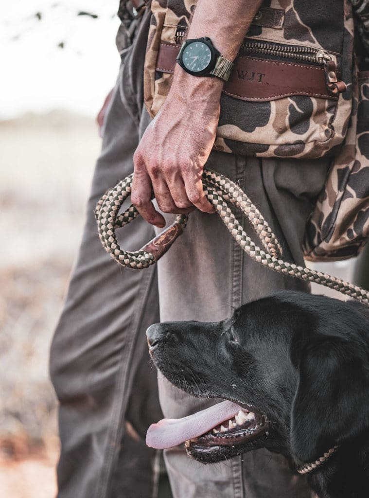 Man in camo walking dog.