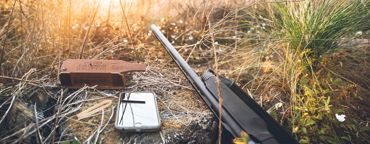 Turkey call, phone and rifle.