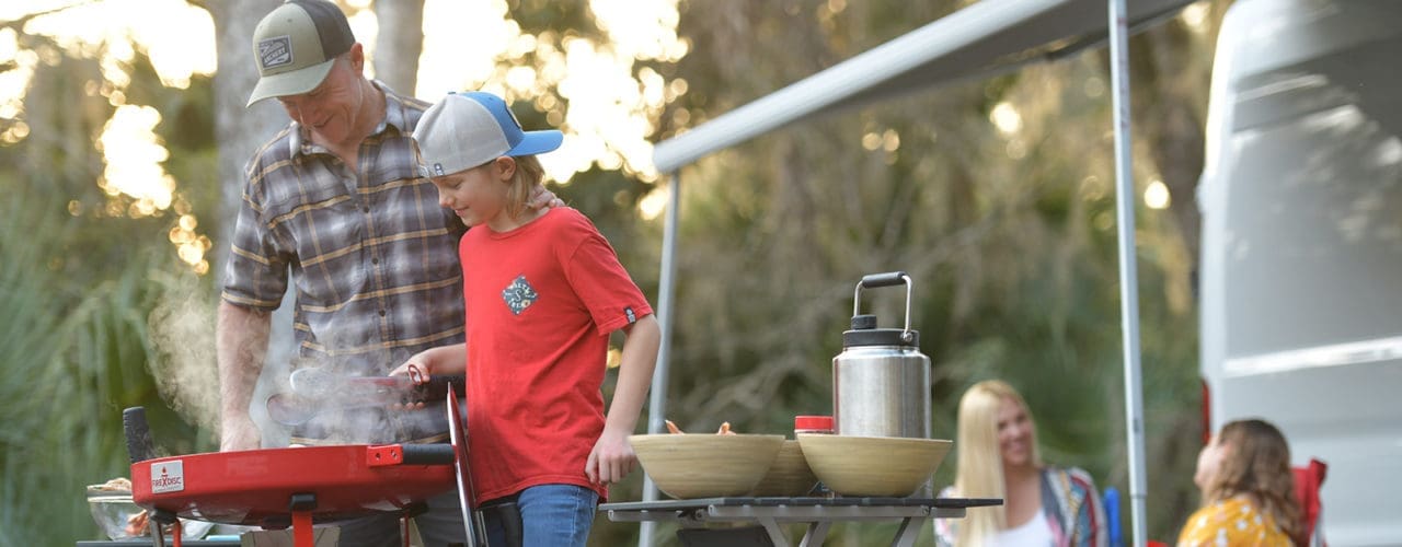 Man and kid grilling on Firedisc.