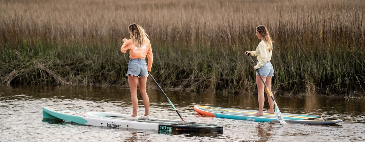 Two women paddleboating.