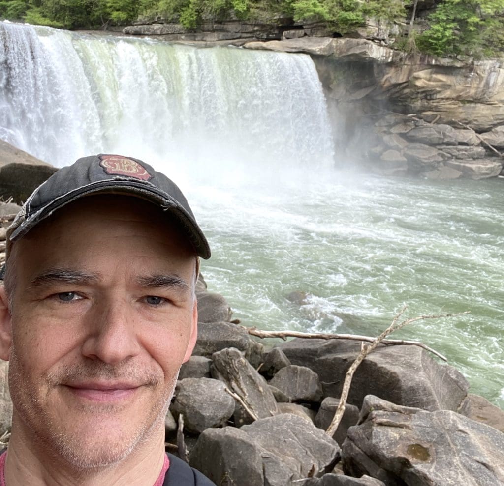 Stephen Childress next to a waterfall.