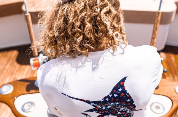 man fishing with fish on back of shirt