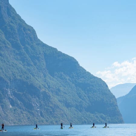 People paddle boarding against a mountain backdrop