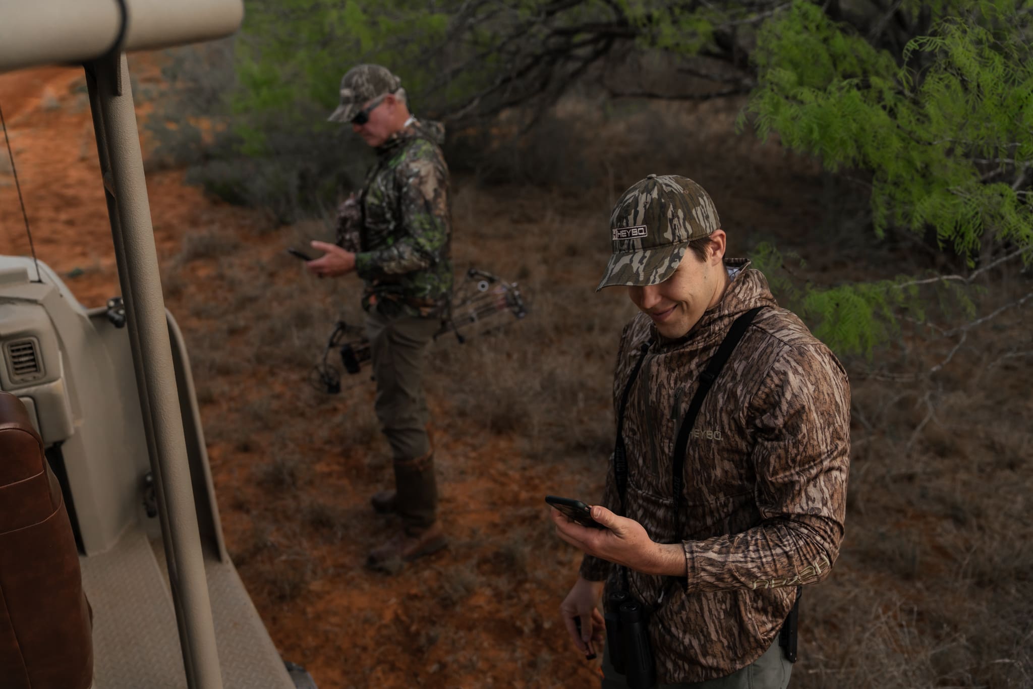 Man in hunting camo looks at his phone