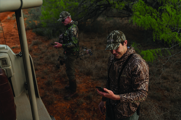 Man in camo checks his phone