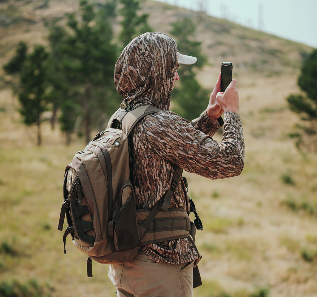 Person in camo taking a picture with their phone