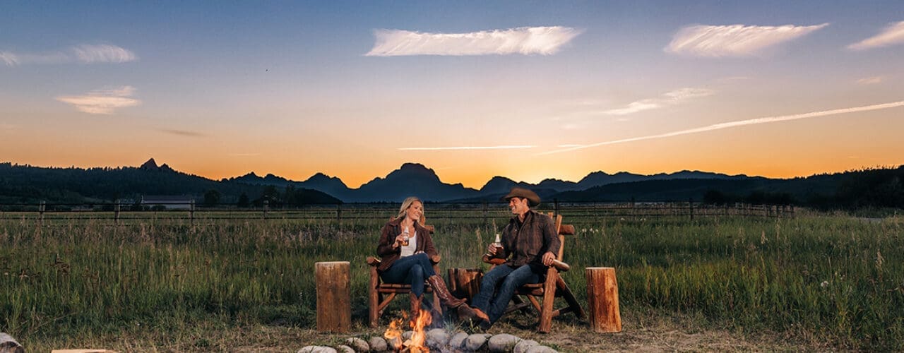 Madison Creek Outfitters promo image of a man and a woman next to a campfire