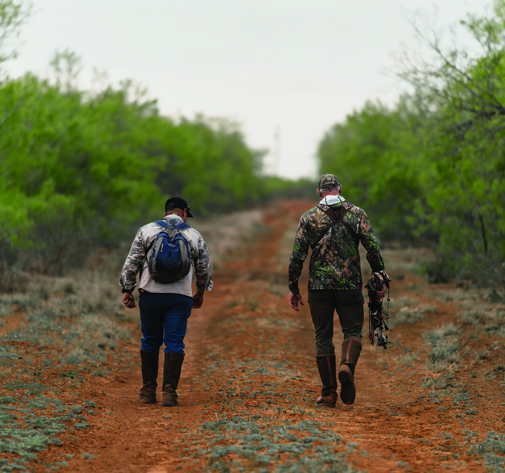 Two hunters walking on a path