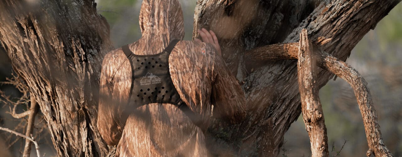 camo, looking through tree