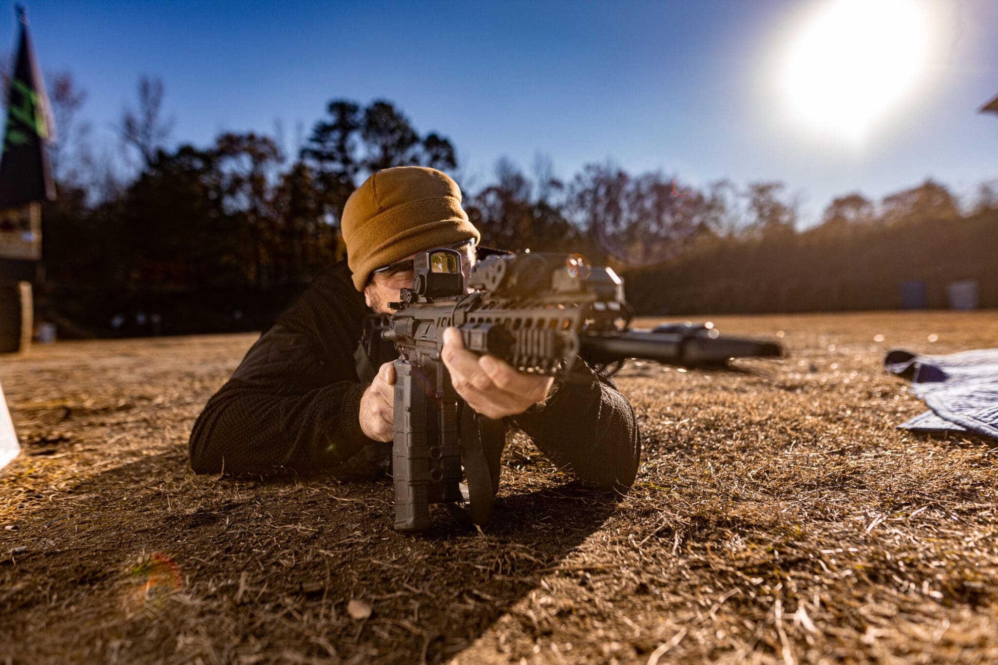 man laying on the ground aiming a rifle